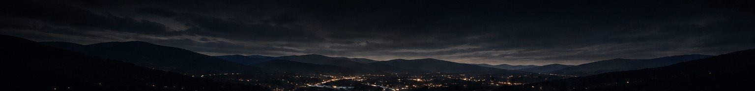 Mountain ridges above a valley town at night